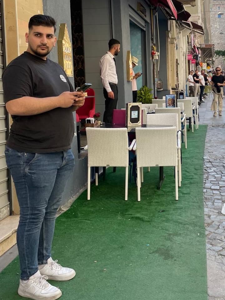 Furkan at 130 kg, standing on a street in Istanbul, phone in hand.
